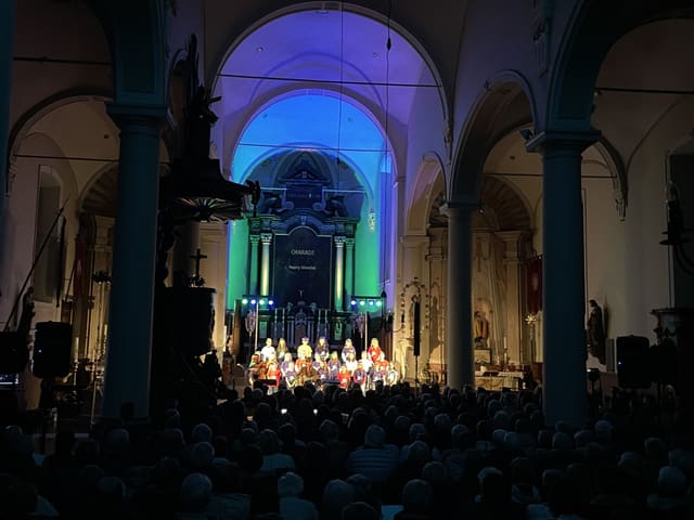 Kerkschip in blauw en groen licht met vol publiek