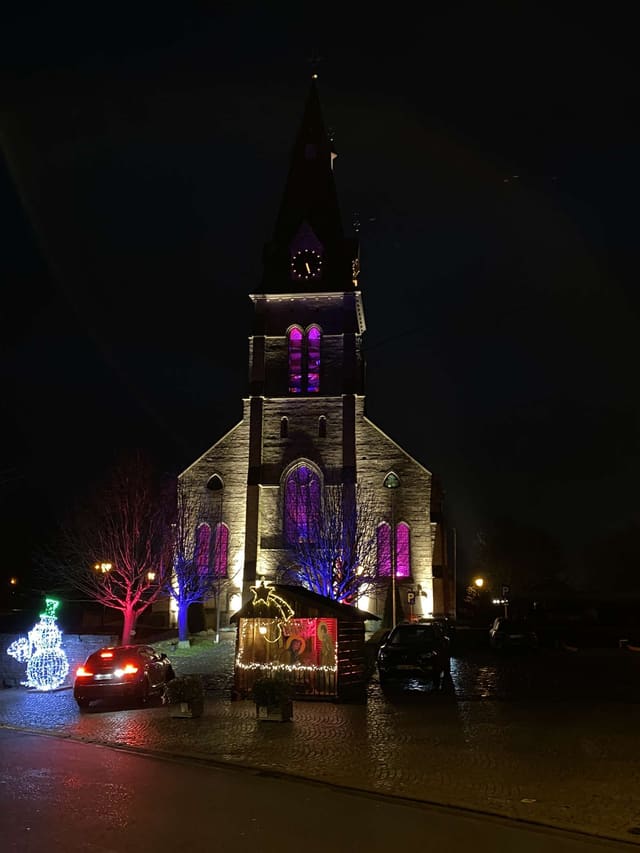 Kerkgevel bij nacht aangelicht in magenta en paars