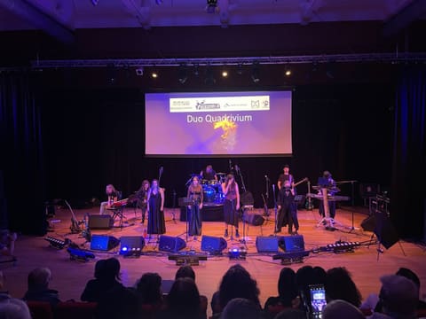 Concertzaal met podiumverlichting en presentatiescherm